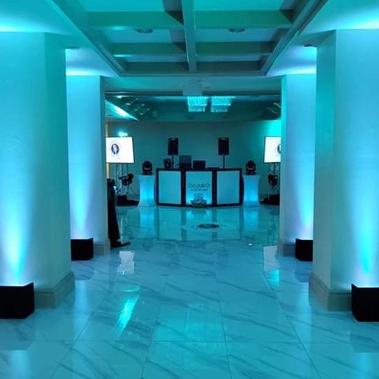 Modern event space with blue lighting and DJ booth.