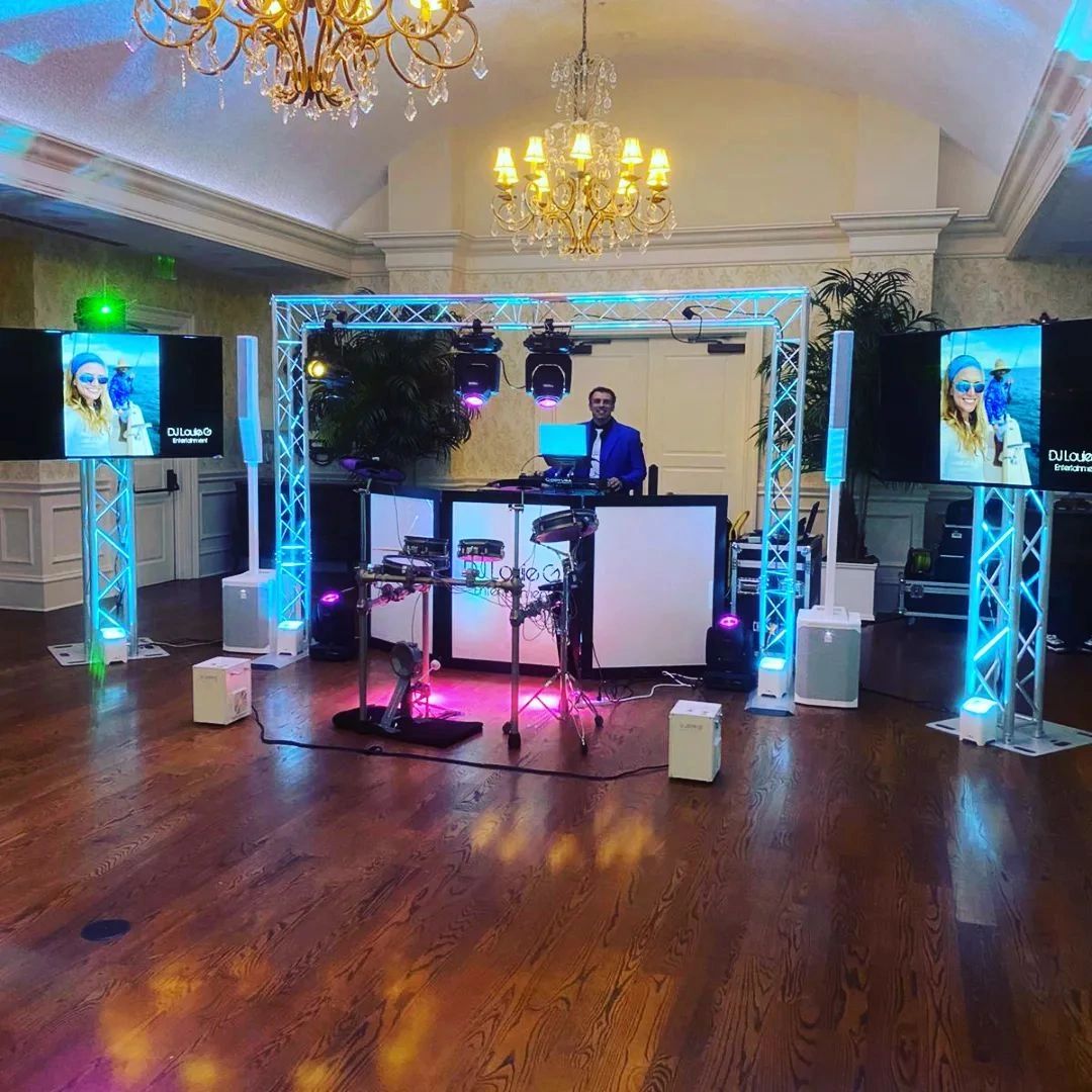 Flat-screen displays flanking the dance floor at a reception